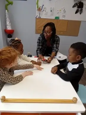 Teacher interacting with children at bilingual daycare in Glenbrook, CT, focusing on Spanish immersion.