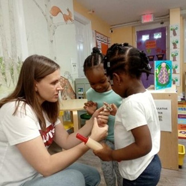 Teacher interacting with young children at a daycare near Darien, CT preschool setting.
