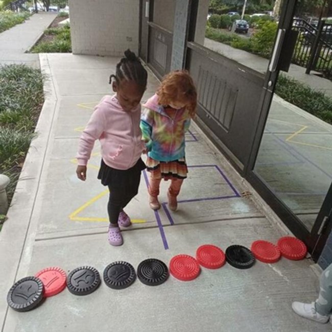 Two children playing with colored discs at a daycare near New Canaan CT.