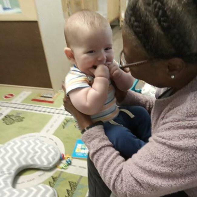 Caregiver and infant at daycare center in Norwalk CT sharing a joyful moment.