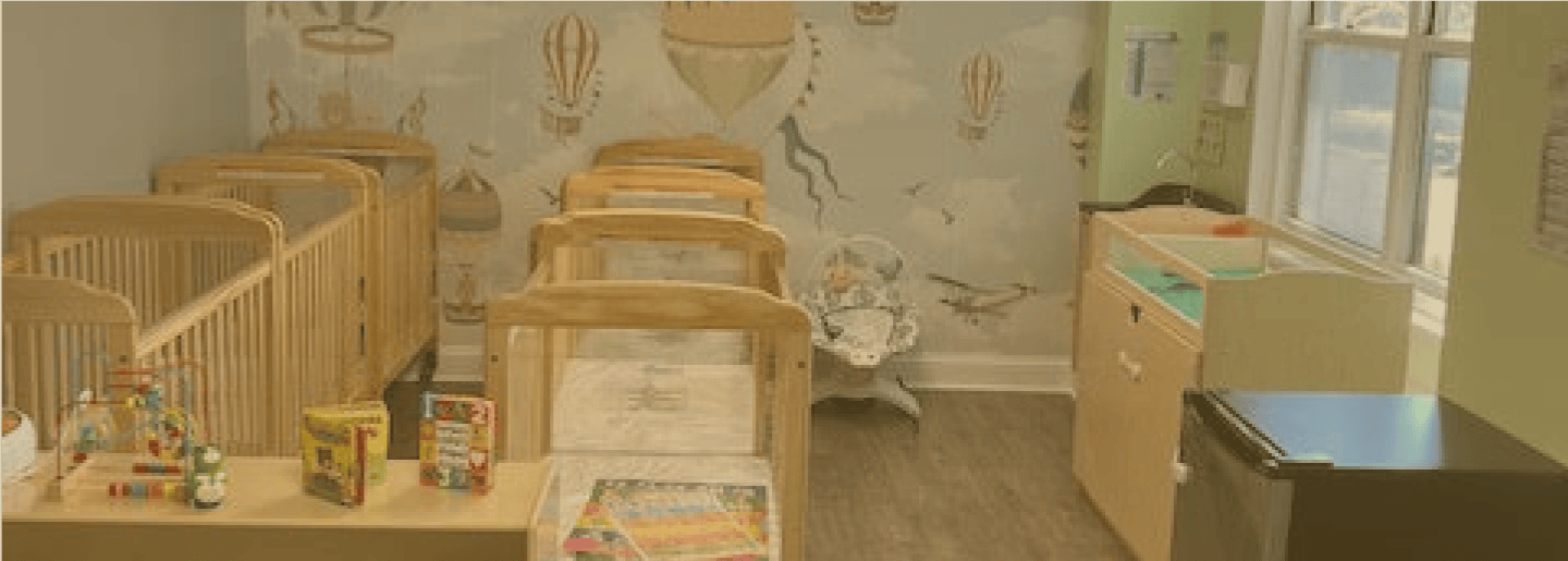 Infant daycare room in Glenbrook CT with cribs and toys