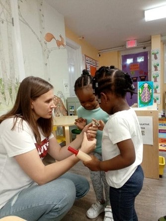 Teacher interacting with children in a pre-K classroom in Glenbrook CT, promoting kindergarten readiness.